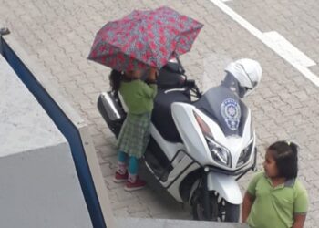 Kırık şemsiyesi ile polis motosikletini yağmurdan korudu