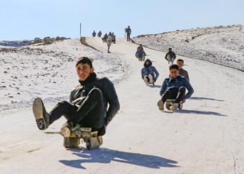 Çocuklar karlı tepeleri kayak pistine dönüştürdü