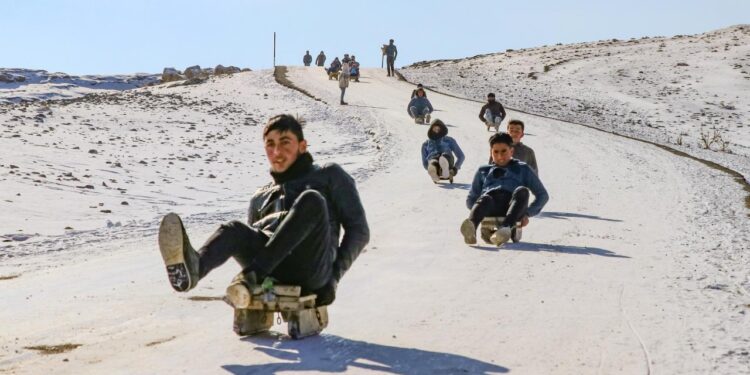 Çocuklar karlı tepeleri kayak pistine dönüştürdü