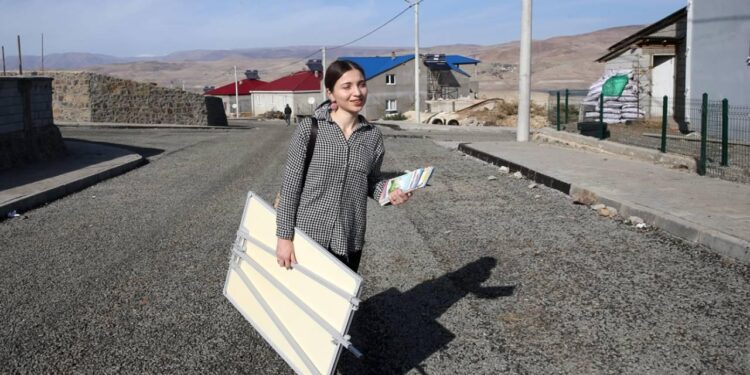 Elinde sınıf tahtasıyla kadınlar için kapı kapı geziyor