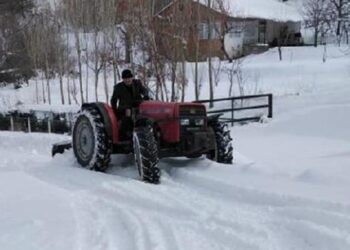 Muhtar, köy içindeki karlı yolları traktörüyle açıyor