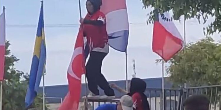 Milli sporcu Rabianur Uzunay, yarıya düşen Türk bayrağını göndere çekti