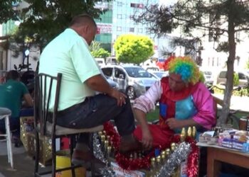 Palyaço kostümüyle hem ayakkabı boyuyor hem insanları eğlendiriyor