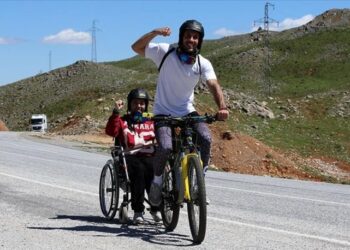 Bisikletle engelli komşusunun hayalini gerçekleştirdi